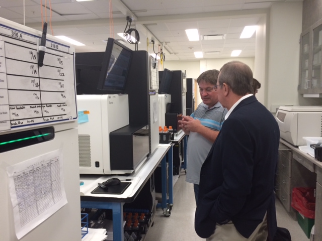 A technician shows Bob some of the equipment used in SCAD genetic research.